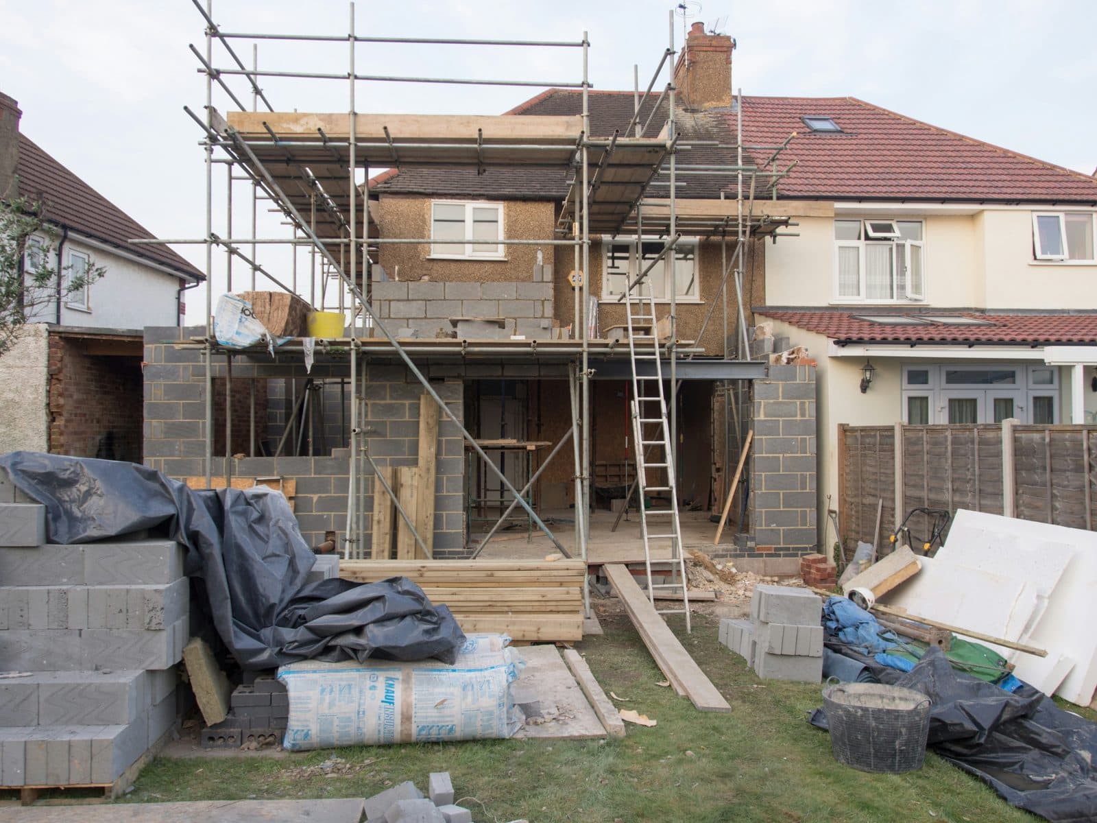 Extension de maison en cours de construction, structure maçonnée sous échafaudage