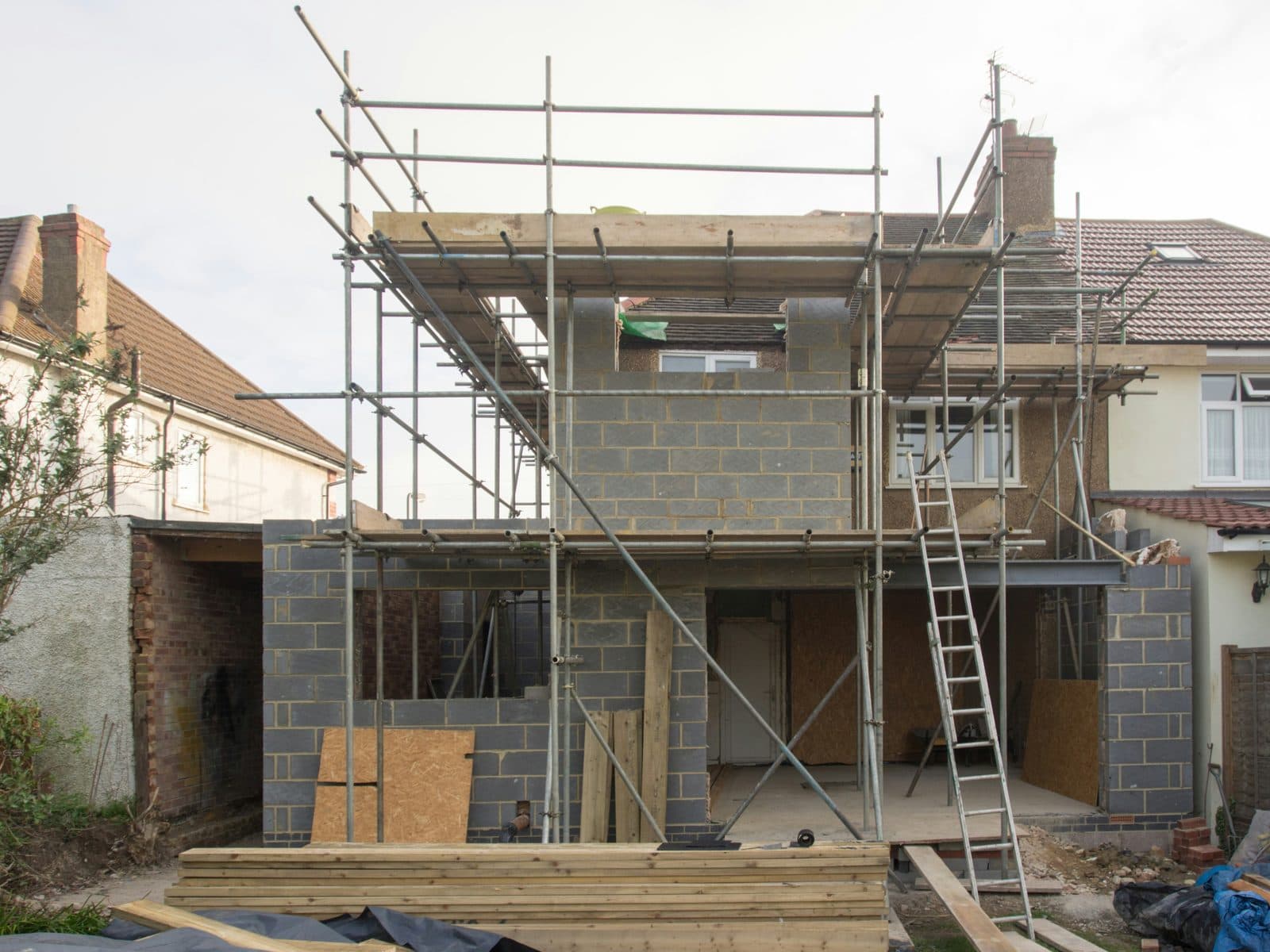 Chantier d'extension : structure montée, échafaudage et accès depuis le jardin